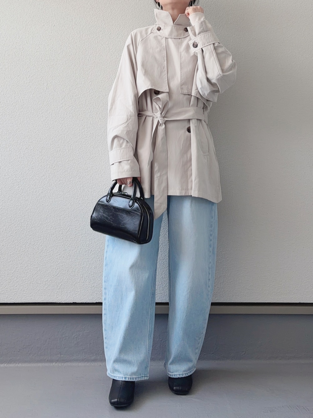 ホワイト系のトレンチコート、ホワイト系のTシャツ/カットソー、ブルー系のデニムパンツを着用したレディースの春コーディネートの5枚目の写真