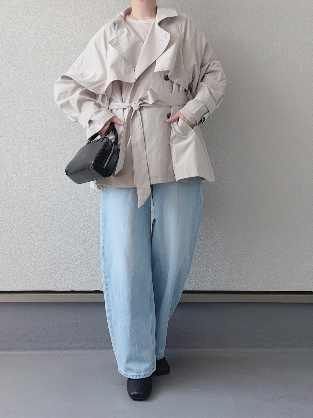 ホワイト系のトレンチコート、ホワイト系のTシャツ/カットソー、ブルー系のデニムパンツを着用したレディースの春コーディネートの4枚目の写真