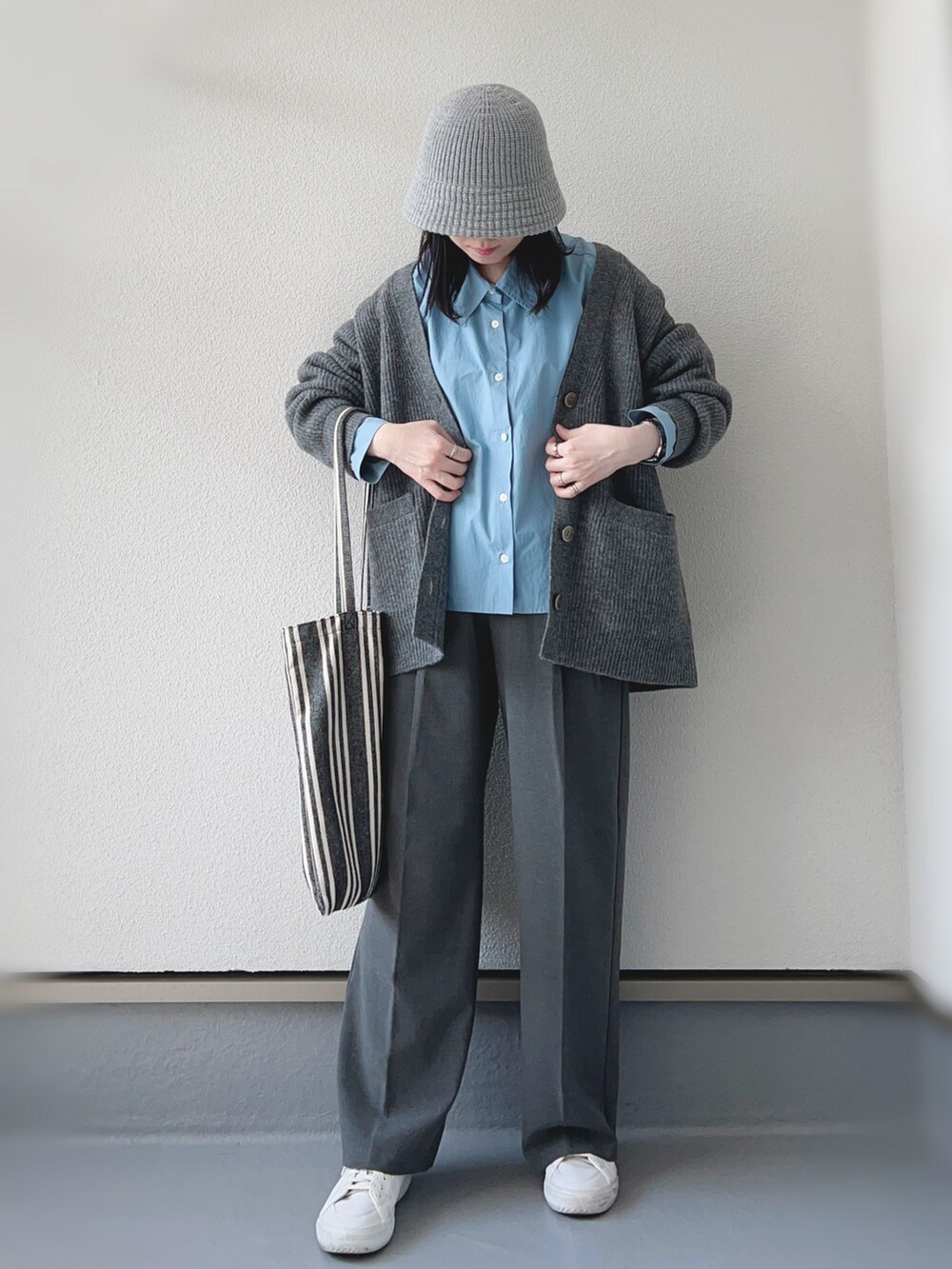 グレー系のカーディガン/ボレロ、ブルー系のシャツ/ブラウス、グレー系のパンツを着用したレディースの秋コーディネートの3枚目の写真