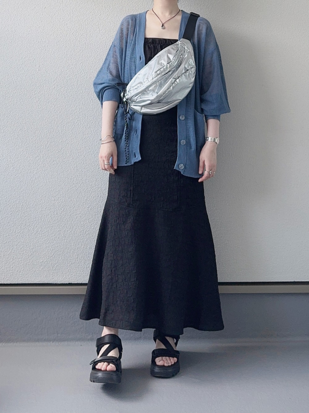 ブルー系のカーディガン/ボレロ、ブラック系のワンピース、シルバー系のボディバッグ/ウエストポーチを着用したレディースの夏コーディネートの2枚目の写真