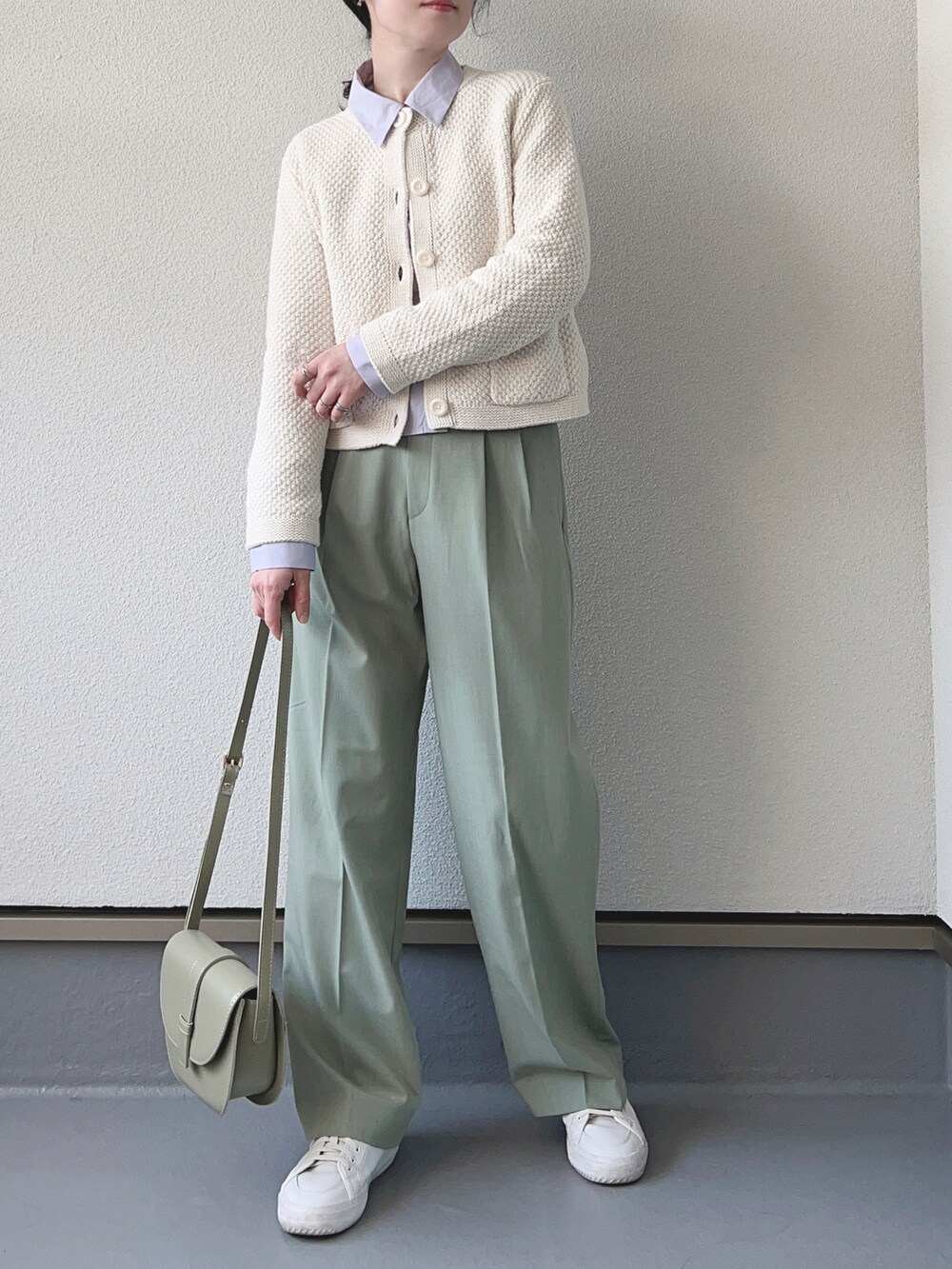 ホワイト系のカーディガン/ボレロ、グリーン系のパンツ、パープル系のシャツ/ブラウスを着用したレディースの冬コーディネートの2枚目の写真