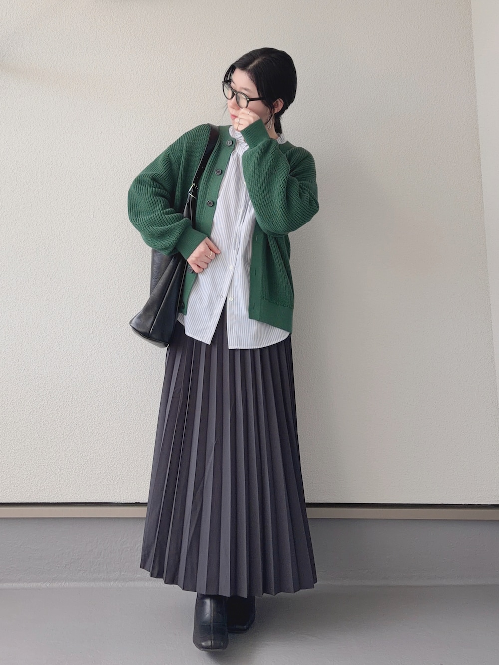 グレー系のスカート、グレー系のシャツ/ブラウス、グリーン系のカーディガン/ボレロを着用したレディースの冬コーディネートの4枚目の写真