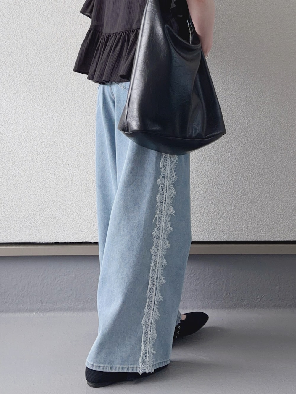 ブルー系のデニムパンツ、ブラック系のシャツ/ブラウス、ブラック系のショルダーバッグを着用したレディースの夏コーディネートの2枚目の写真
