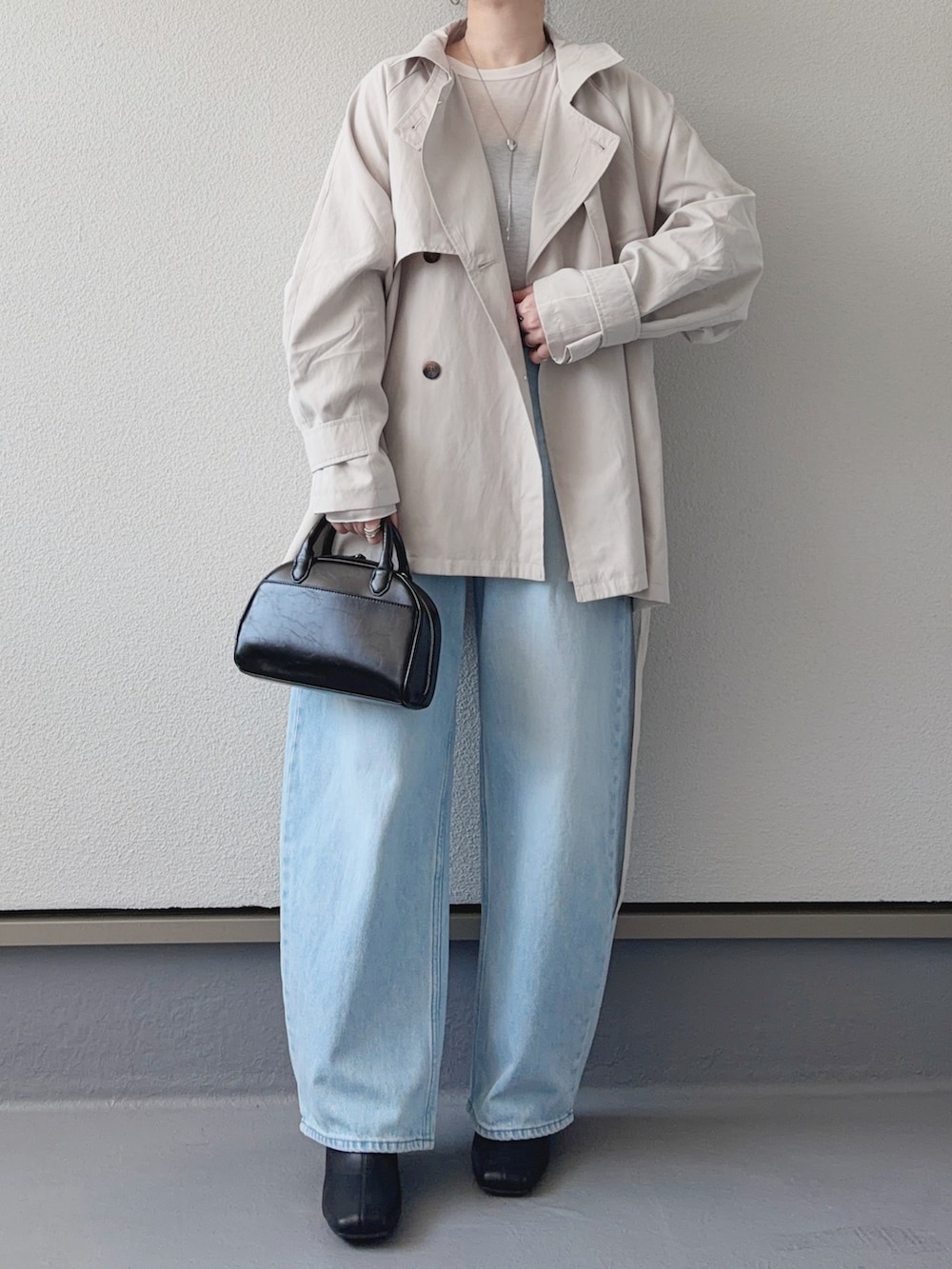 ホワイト系のトレンチコート、ホワイト系のTシャツ/カットソー、ブルー系のデニムパンツを着用したレディースの春コーディネートの2枚目の写真