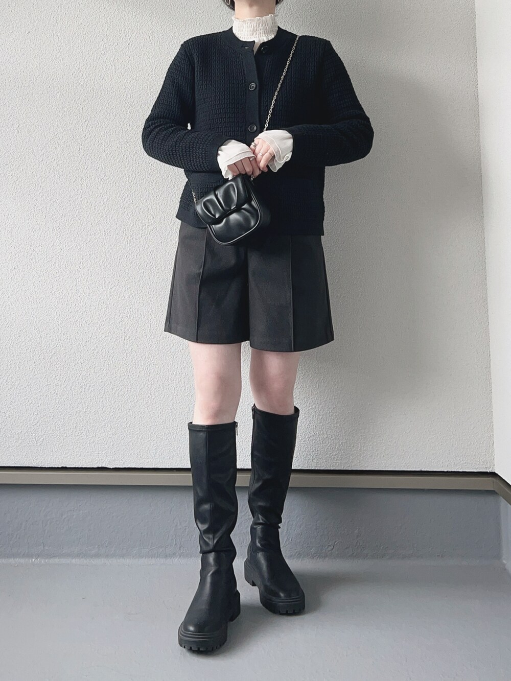 ブラック系のカーディガン/ボレロ、ホワイト系のシャツ/ブラウス、グレー系のパンツを着用したレディースの冬コーディネートの3枚目の写真