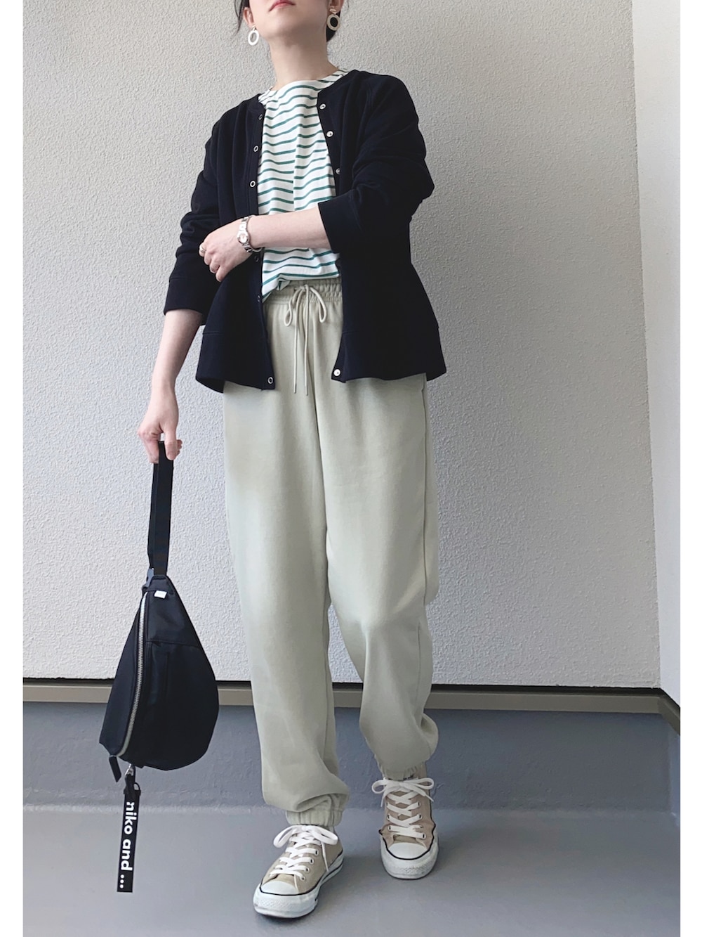 ホワイト系のTシャツ/カットソー、ブラック系のカーディガン/ボレロ、グリーン系のスウェットパンツを着用したレディースの春コーディネートの2枚目の写真