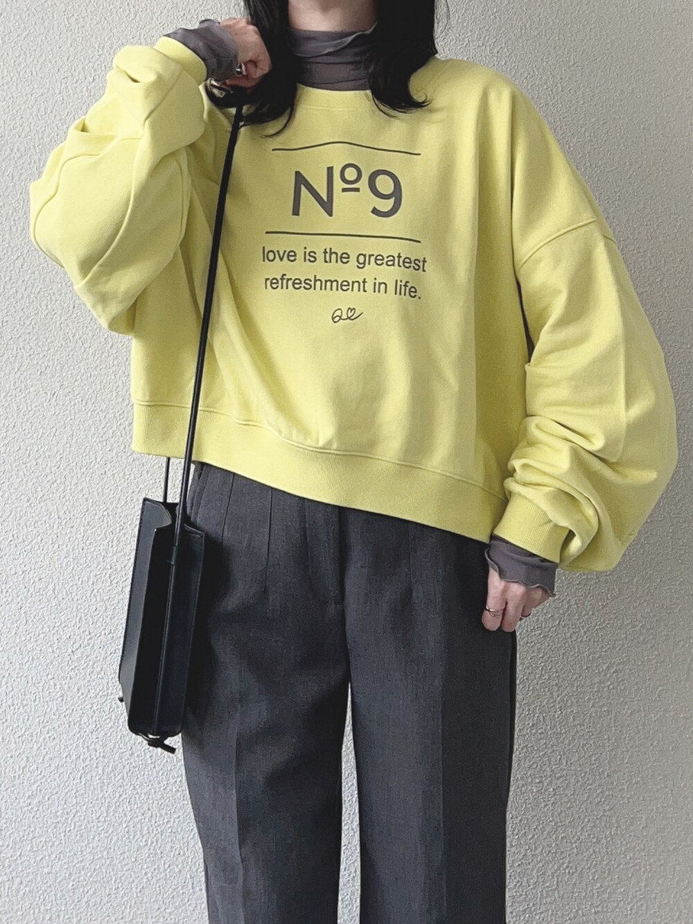 イエロー系のスウェット、グレー系のパンツ、ブラック系のシューズを着用したレディースの冬コーディネートの3枚目の写真