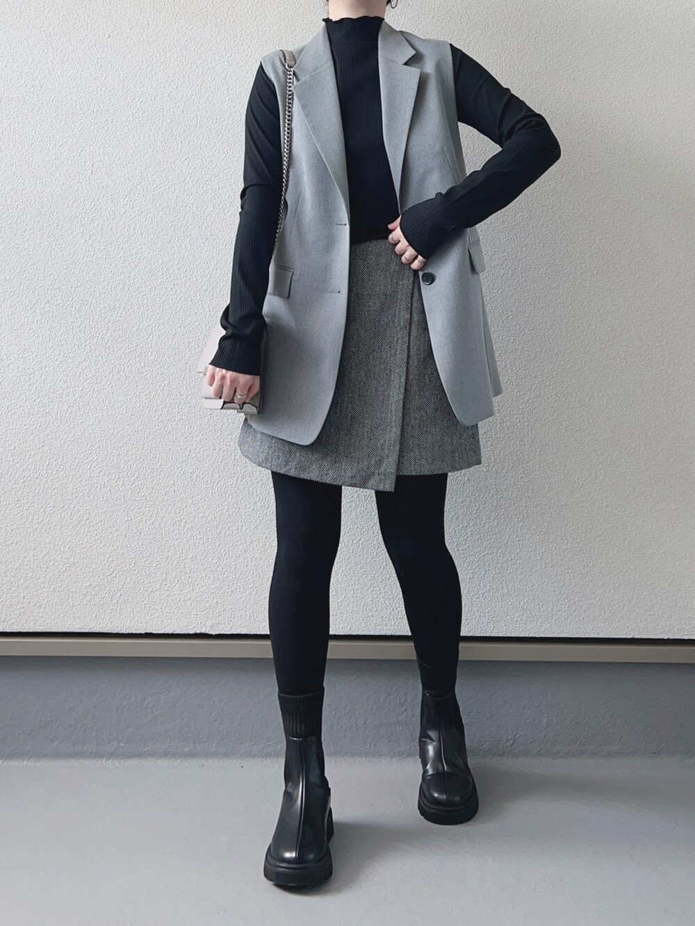 ブラック系のTシャツ/カットソー、グレー系のベスト、グレー系のスカートを着用したレディースの秋コーディネートの3枚目の写真