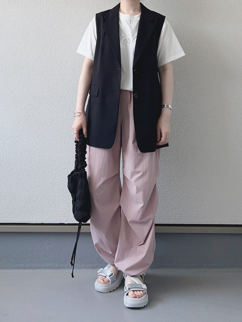ホワイト系のTシャツ/カットソー、ブラック系のベスト、ピンク系のパンツを着用したレディースの春コーディネートの3枚目の写真
