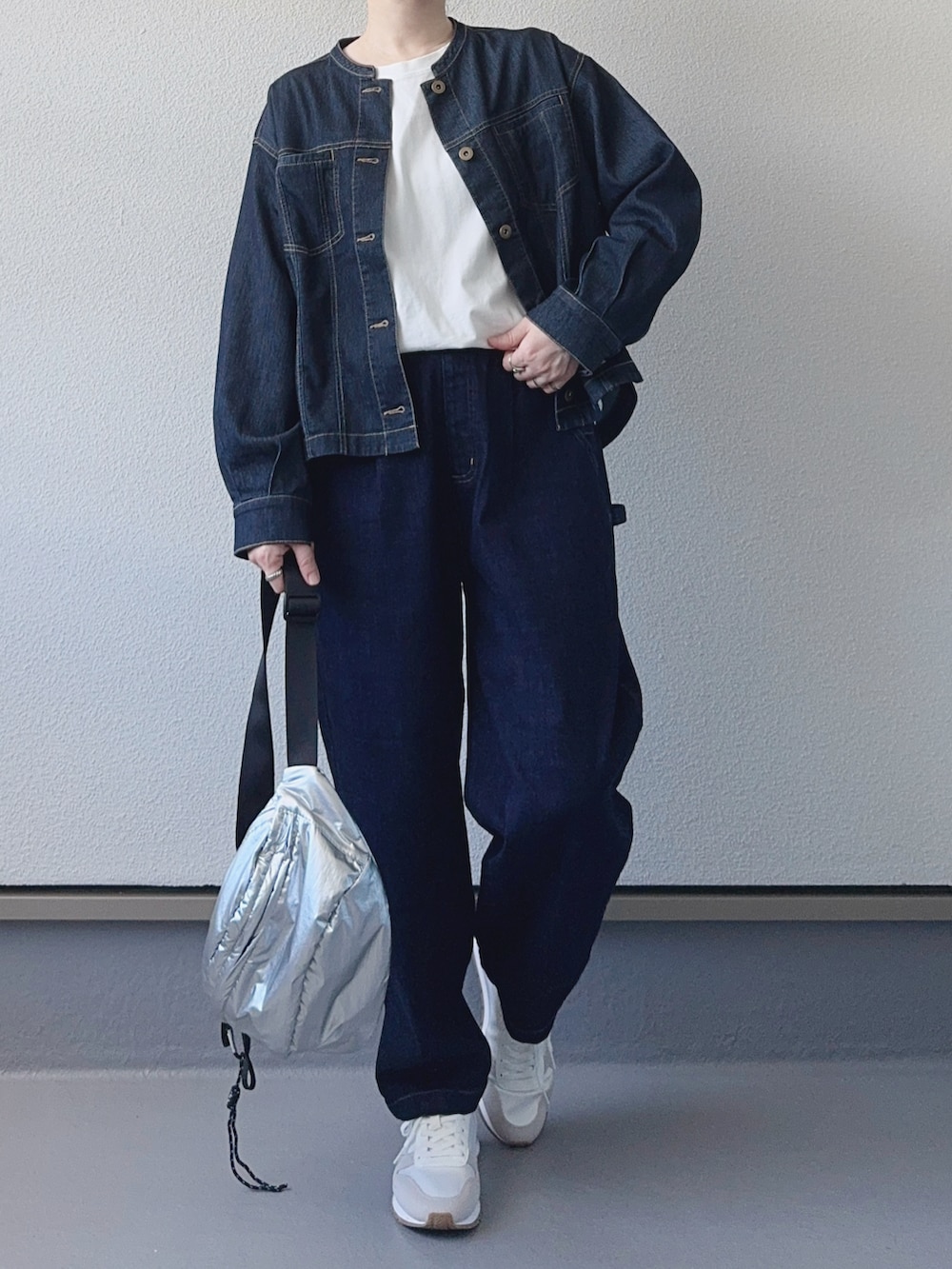 シルバー系のボディバッグ/ウエストポーチ、ブルー系のブルゾン、ブルー系のデニムパンツを着用したレディースの秋コーディネートの2枚目の写真