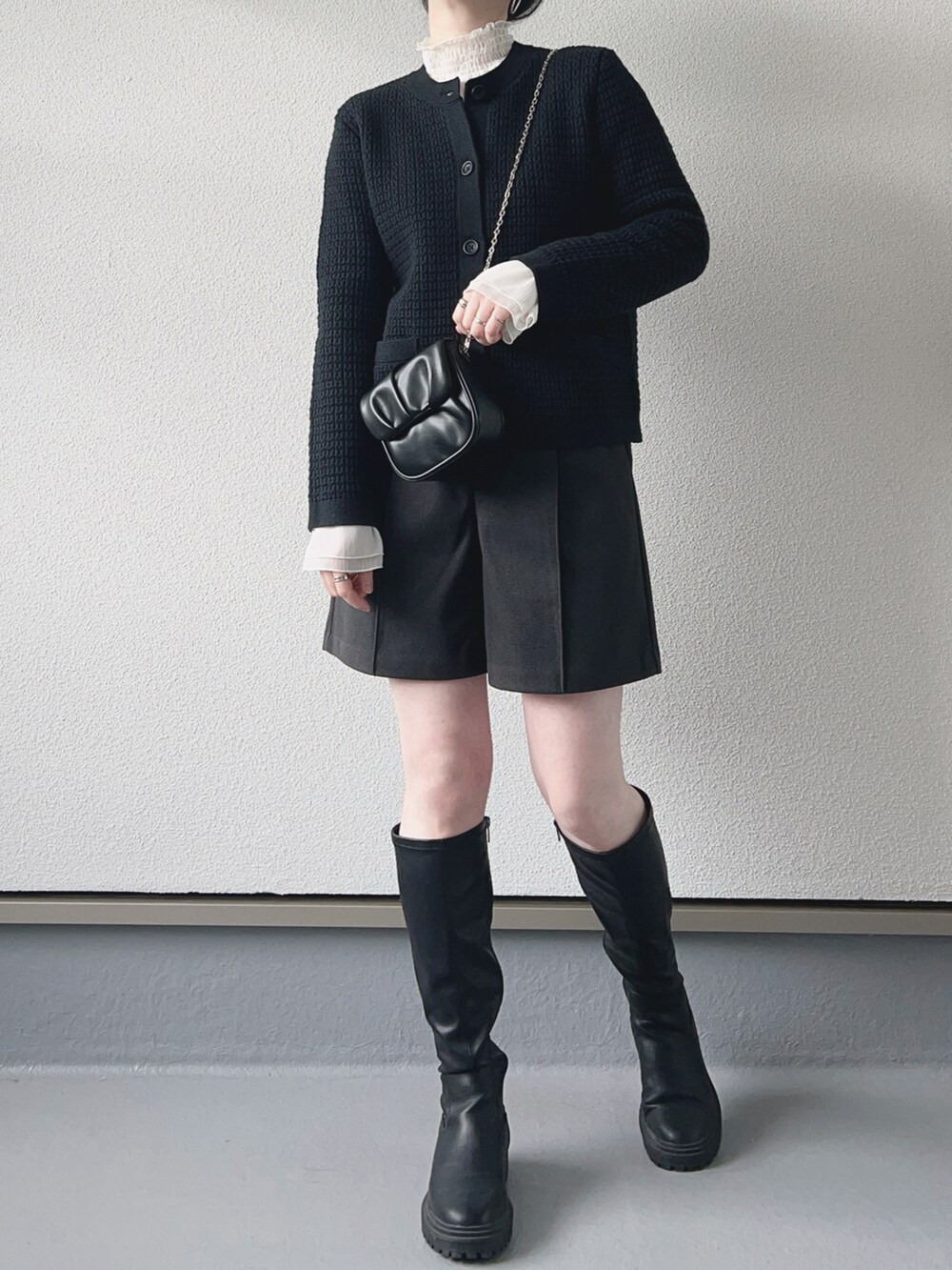 ブラック系のカーディガン/ボレロ、ホワイト系のシャツ/ブラウス、グレー系のパンツを着用したレディースの冬コーディネートの2枚目の写真