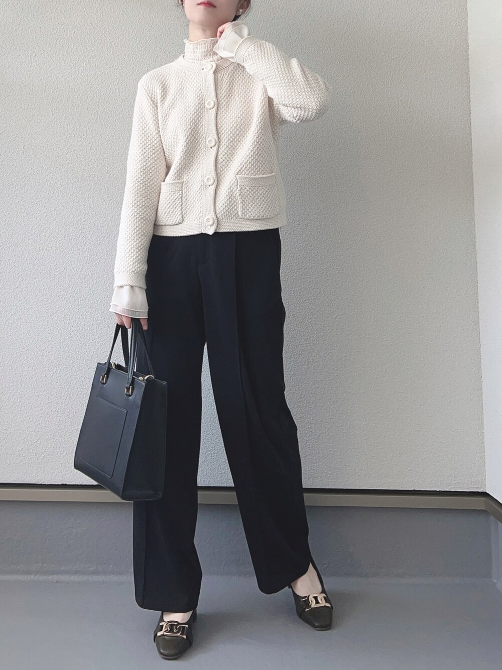 ホワイト系のカーディガン/ボレロ、ホワイト系のシャツ/ブラウス、ブラック系のパンツを着用したレディースの春コーディネートの2枚目の写真