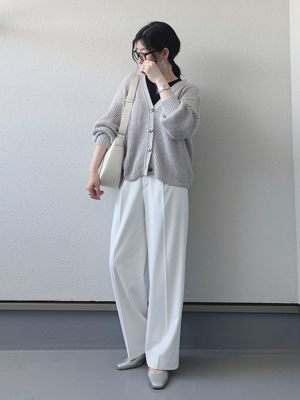 グレー系のカーディガン/ボレロ、ブラック系のタンクトップ、ホワイト系のスラックスを着用したレディースの春コーディネートの2枚目の写真