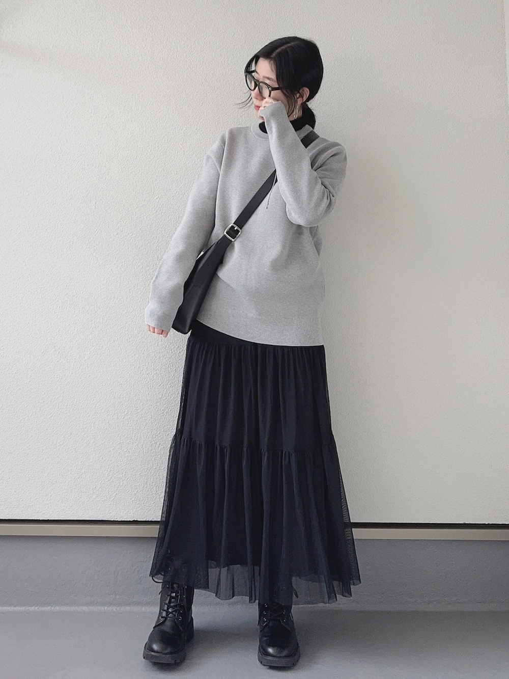 グレー系のニット/セーター、ブラック系のTシャツ/カットソー、ブラック系のスカートを着用したレディースの冬コーディネートの3枚目の写真
