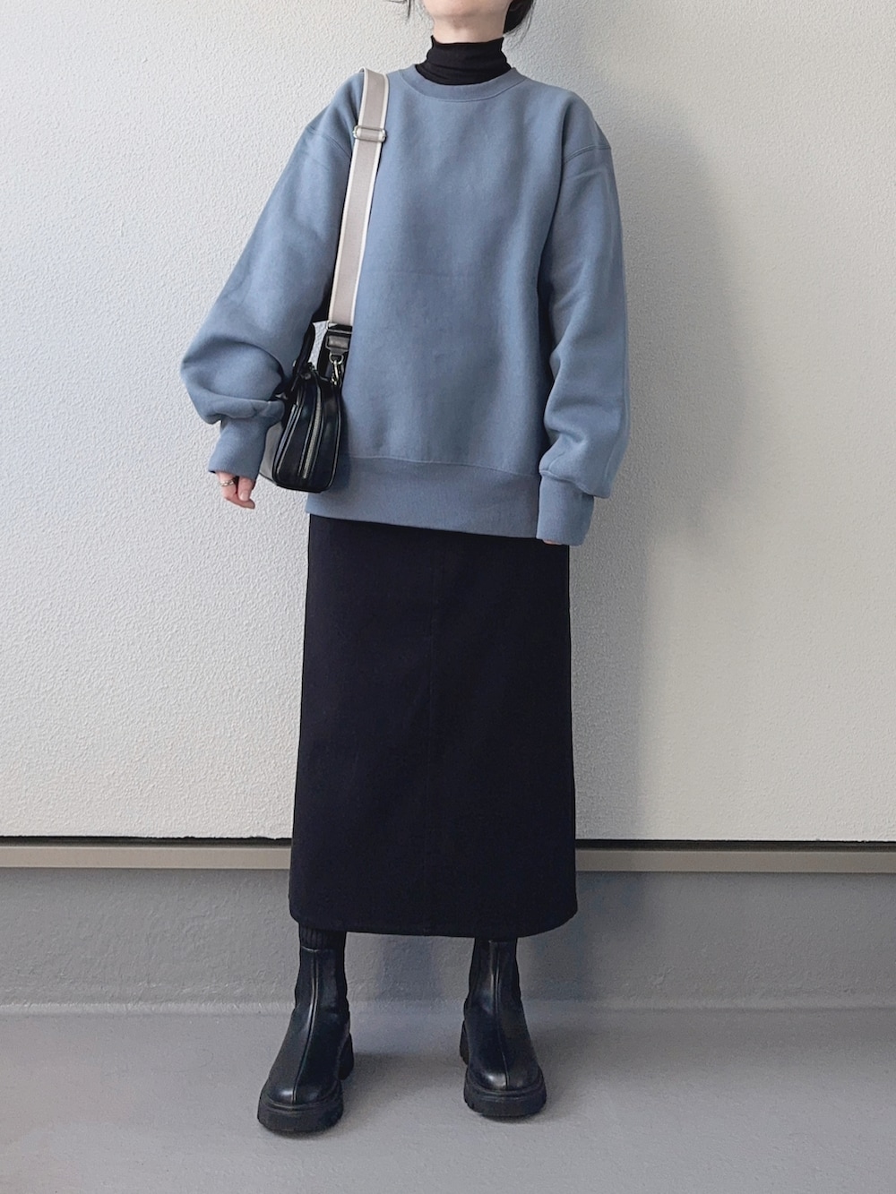 ブルー系のスウェット、ブラック系のTシャツ/カットソー、ブラック系のショルダーバッグを着用したレディースの冬コーディネートの2枚目の写真