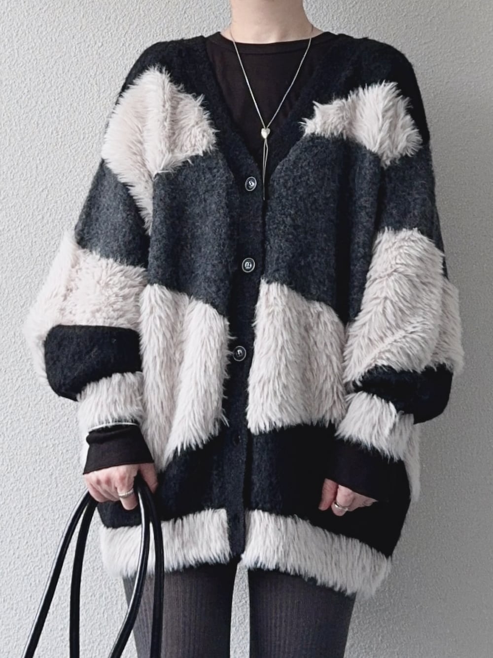 ブラック系のカーディガン/ボレロ、ブラック系のその他パンツ、ブラック系のブーツを着用したレディースの秋コーディネートの3枚目の写真