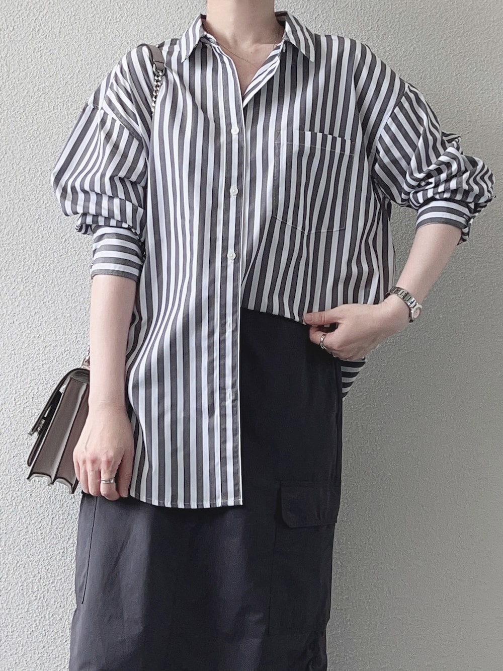 グレー系のシャツ/ブラウス、グレー系のスカート、ブラック系のサンダルを着用したレディースの秋コーディネートの3枚目の写真