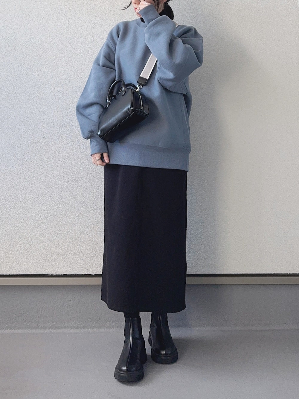 ブルー系のスウェット、ブラック系のTシャツ/カットソー、ブラック系のショルダーバッグを着用したレディースの冬コーディネートの3枚目の写真