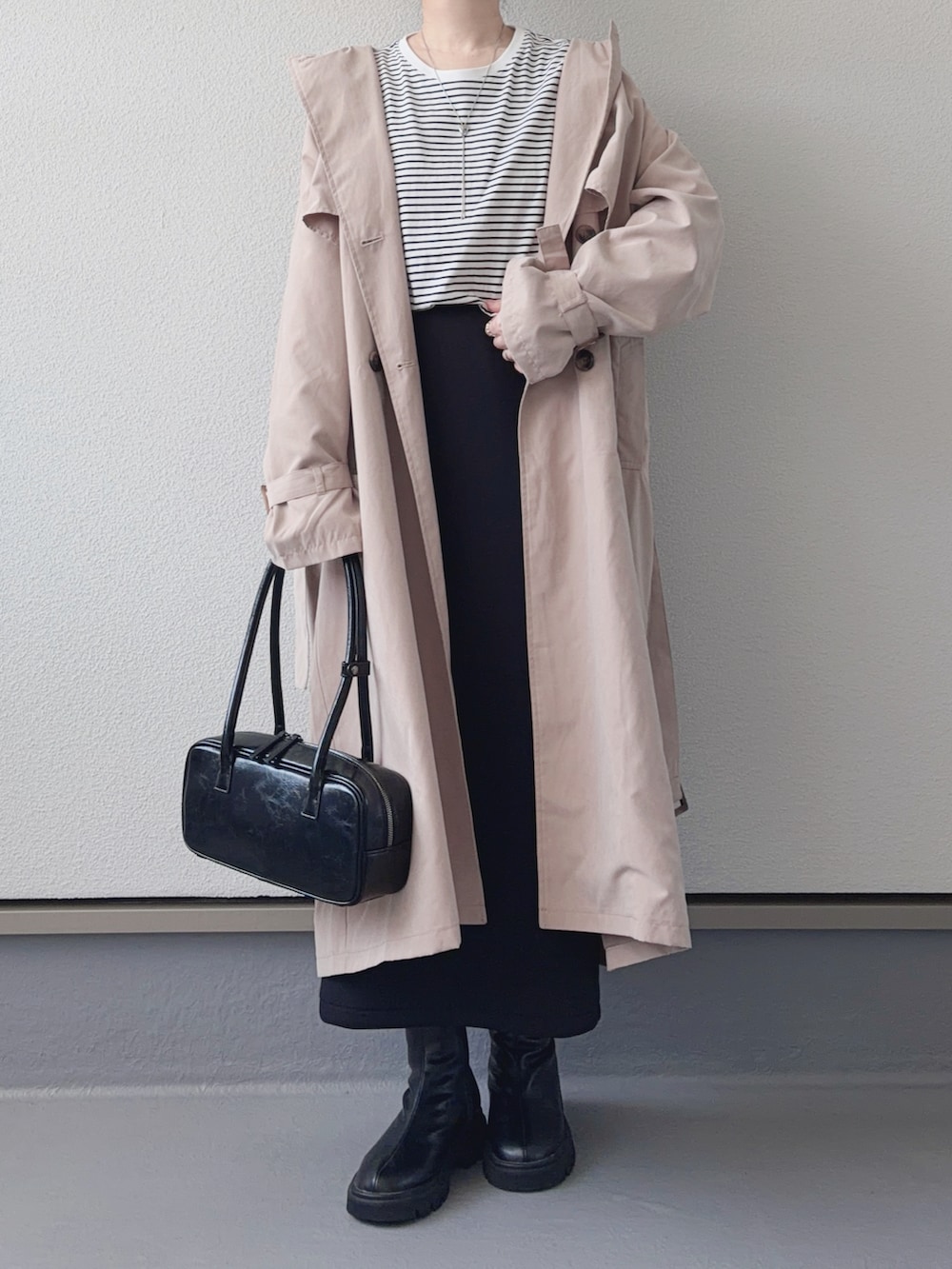 ベージュ系のトレンチコート、ブラック系のブーツ、ホワイト系のTシャツ/カットソーを着用したレディースの春コーディネートの3枚目の写真
