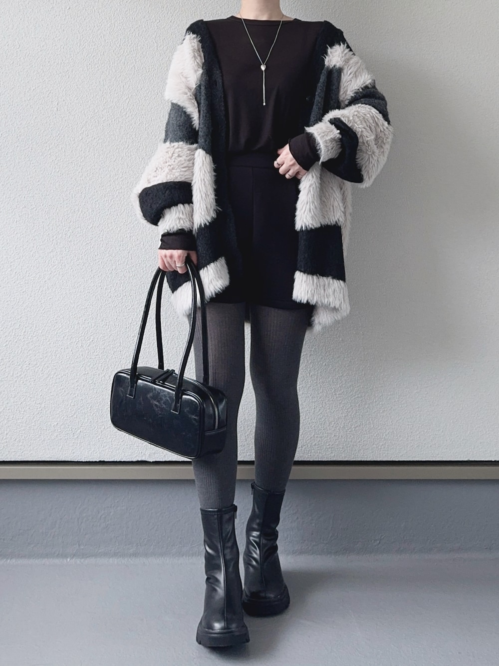 ブラック系のカーディガン/ボレロ、ブラック系のその他パンツ、ブラック系のブーツを着用したレディースの秋コーディネートの4枚目の写真