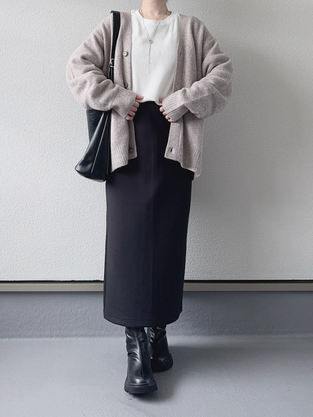ベージュ系のカーディガン/ボレロ、ホワイト系のTシャツ/カットソー、ブラック系のスカートを着用したレディースの秋コーディネートの3枚目の写真