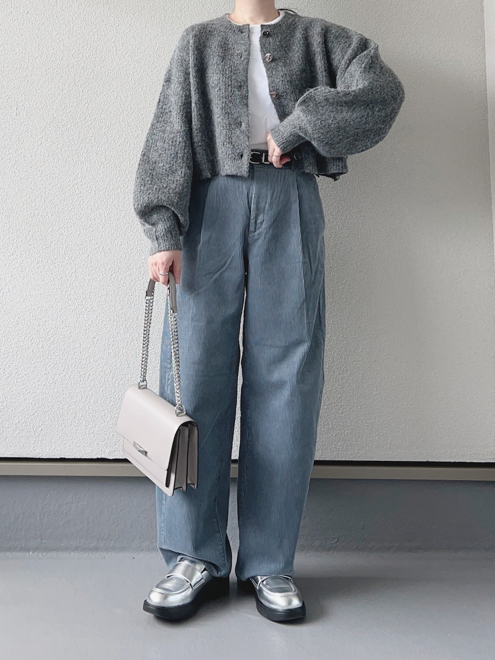 グレー系のカーディガン/ボレロ、ホワイト系のTシャツ/カットソー、ブルー系のパンツを着用したレディースの秋コーディネートの2枚目の写真