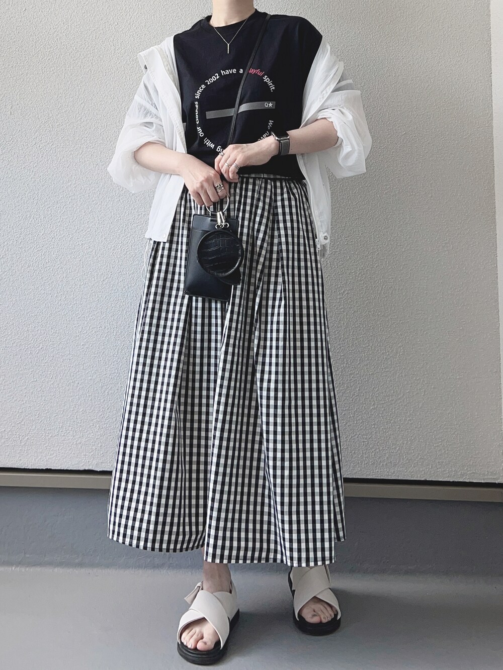 ブラック系のTシャツ/カットソー、ホワイト系のマウンテンパーカー、ブラック系のスカートを着用したレディースの夏コーディネートの2枚目の写真