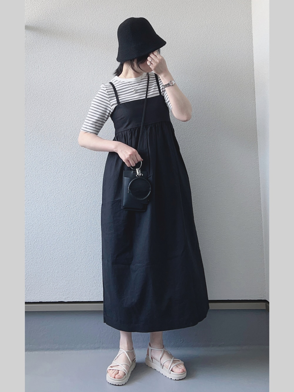 ブラック系のワンピース/ドレス、ホワイト系のサンダル、ホワイト系のTシャツ/カットソーを着用したレディースの春コーディネートの2枚目の写真