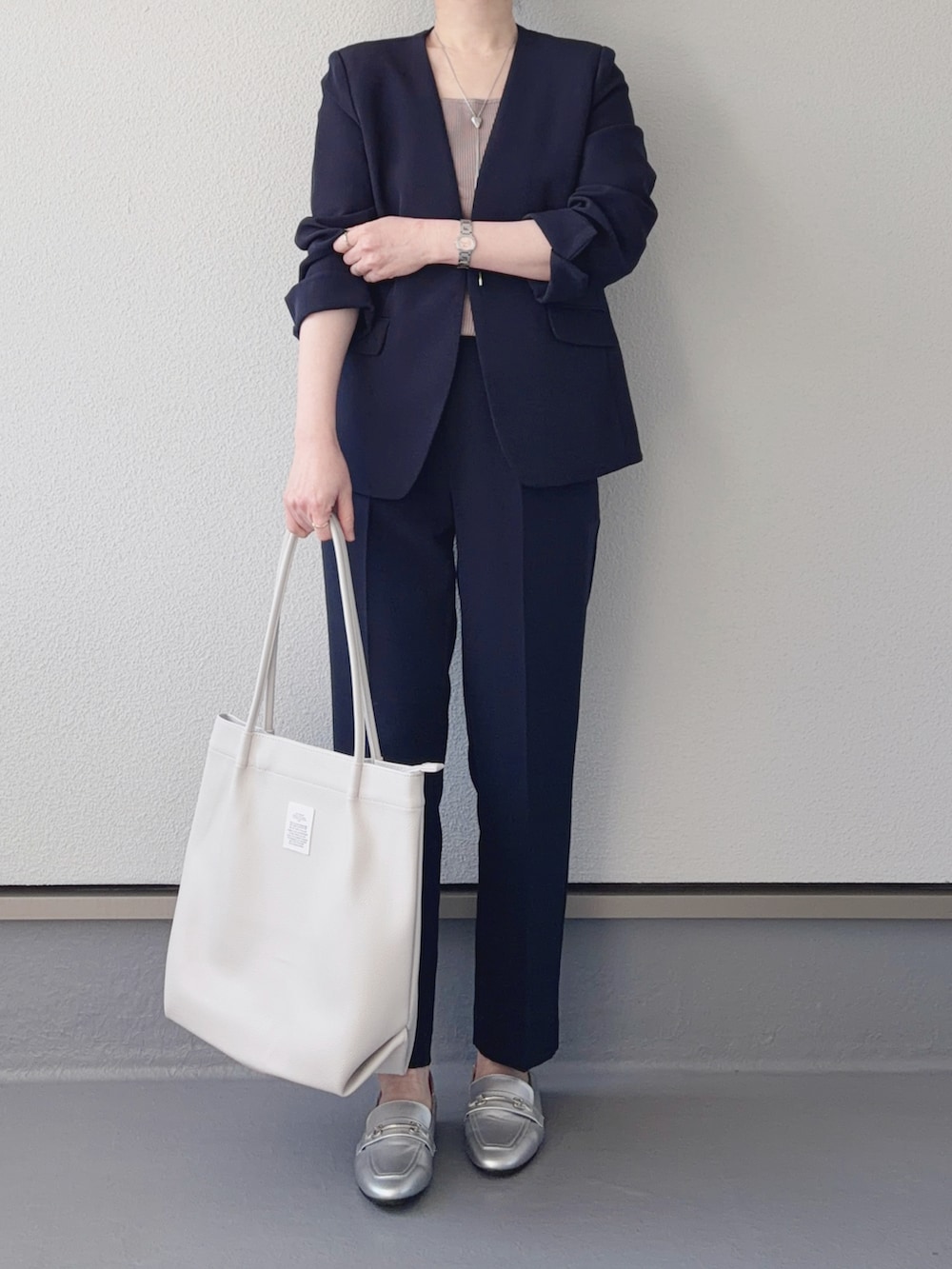 ブルー系のノーカラージャケット、ブルー系のその他パンツ、ホワイト系のトートバッグを着用したレディースの冬コーディネートの3枚目の写真