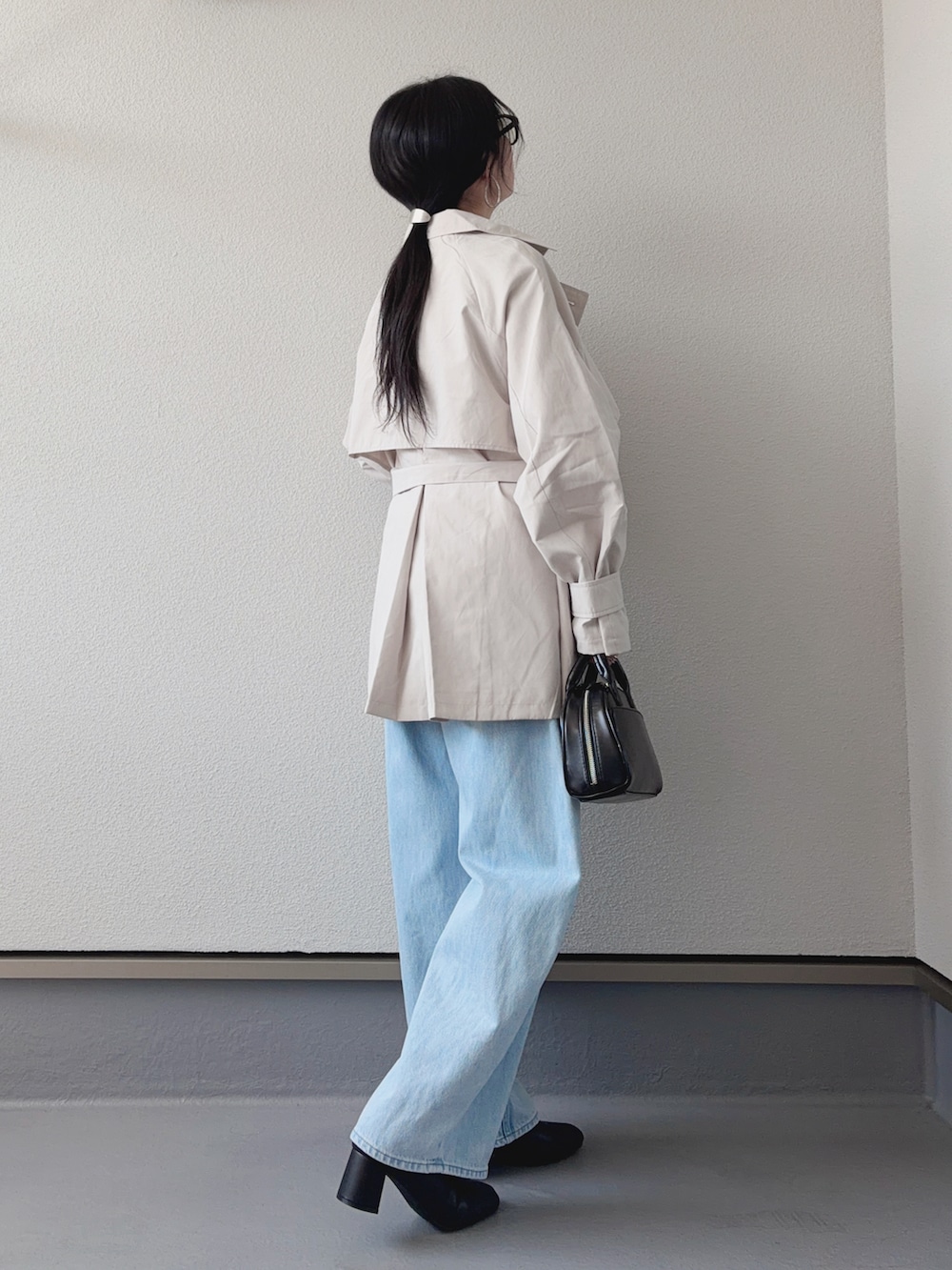 ホワイト系のトレンチコート、ホワイト系のTシャツ/カットソー、ブルー系のデニムパンツを着用したレディースの春コーディネートの3枚目の写真