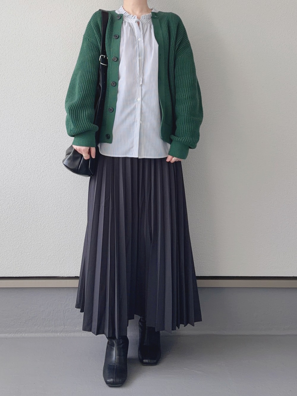 グレー系のスカート、グレー系のシャツ/ブラウス、グリーン系のカーディガン/ボレロを着用したレディースの冬コーディネートの3枚目の写真