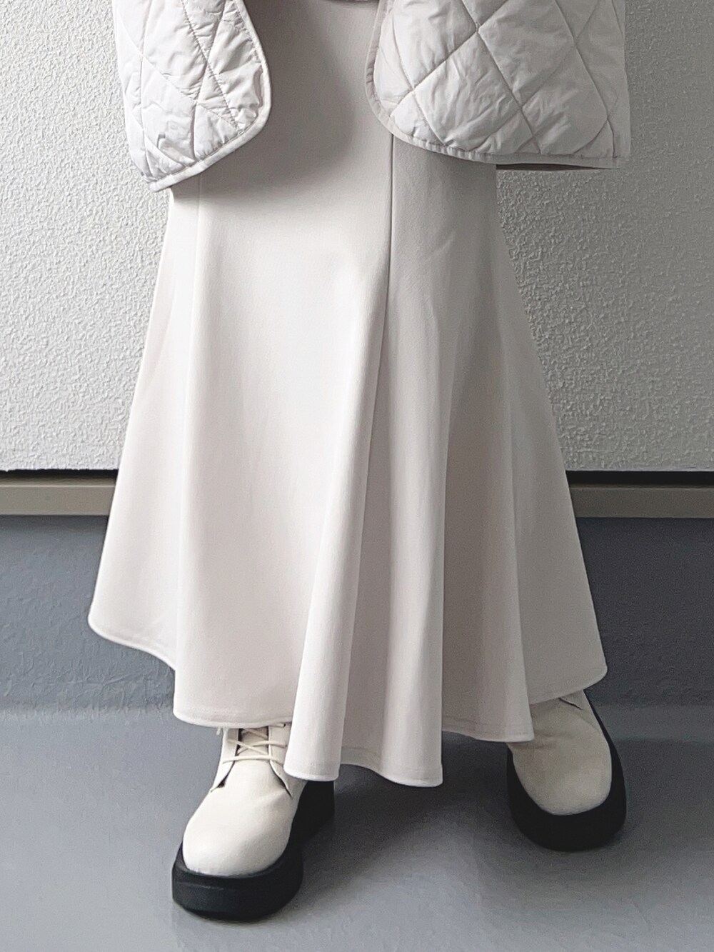 グレー系のブルゾン、ホワイト系のベスト、ブラック系のTシャツ/カットソーを着用したレディースの秋コーディネートの3枚目の写真