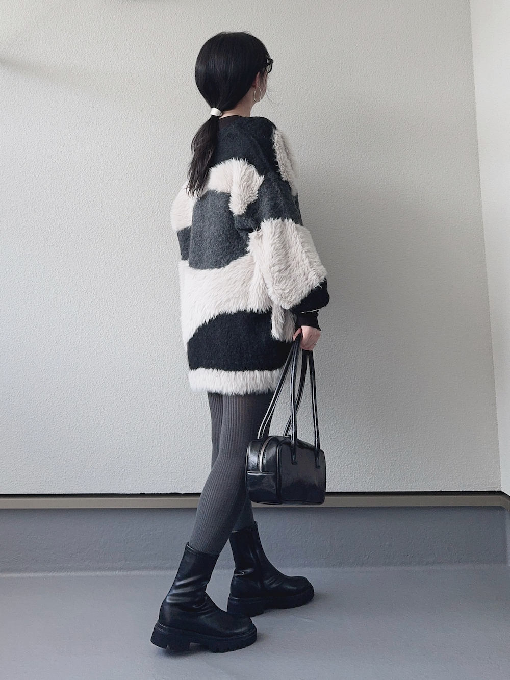 ブラック系のカーディガン/ボレロ、ブラック系のその他パンツ、ブラック系のブーツを着用したレディースの秋コーディネートの2枚目の写真