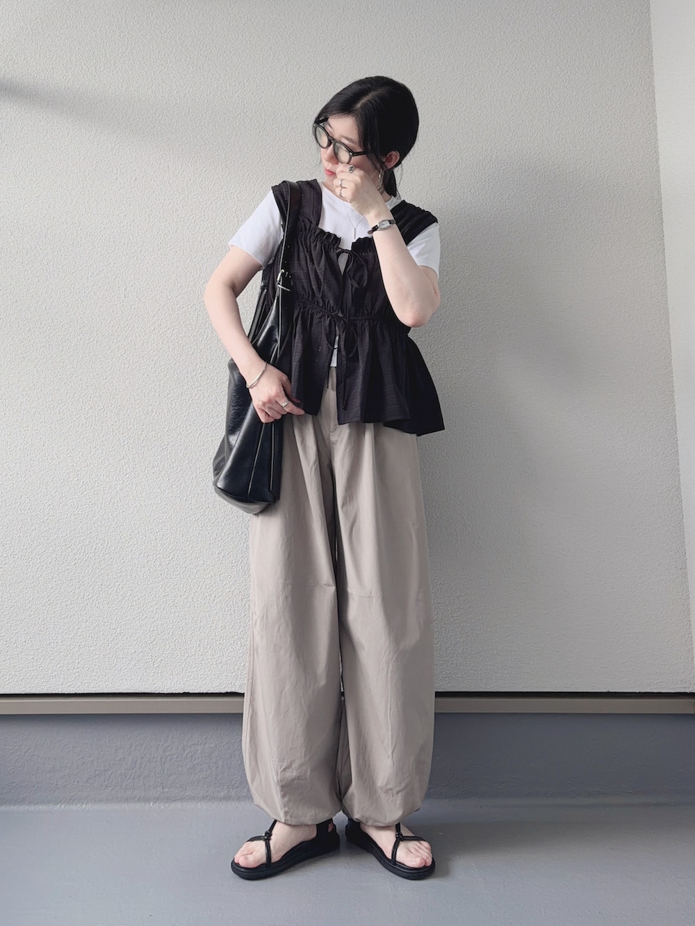 ブラック系のシャツ/ブラウス、ホワイト系のTシャツ/カットソー、ベージュ系のパンツを着用したレディースの夏コーディネートの4枚目の写真