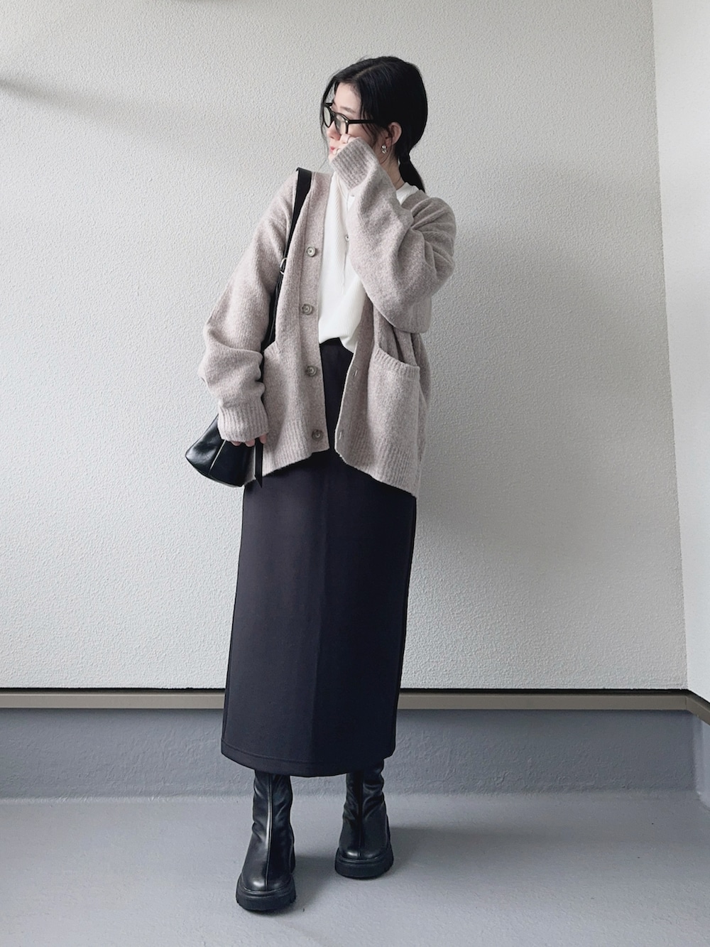 ベージュ系のカーディガン/ボレロ、ホワイト系のTシャツ/カットソー、ブラック系のスカートを着用したレディースの秋コーディネートの4枚目の写真