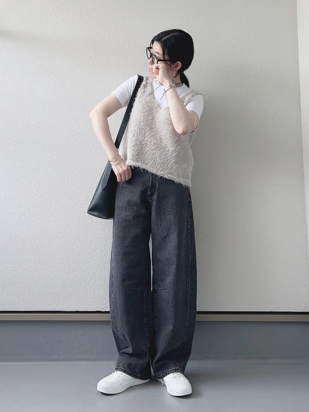グレー系のベスト、グレー系のデニムパンツ、ホワイト系のTシャツ/カットソーを着用したレディースの秋コーディネートの2枚目の写真