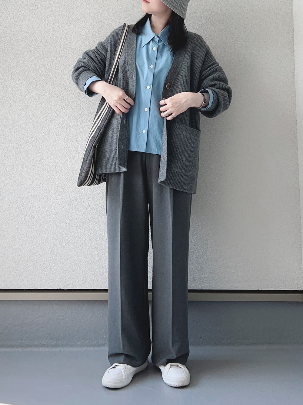 グレー系のカーディガン/ボレロ、ブルー系のシャツ/ブラウス、グレー系のパンツを着用したレディースの秋コーディネートの2枚目の写真