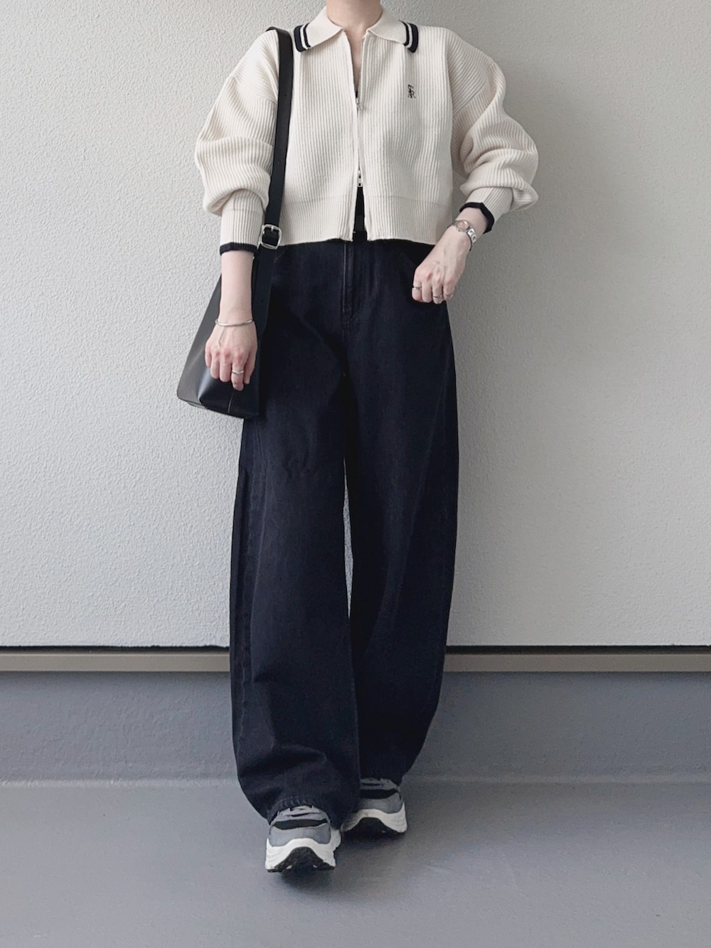 ホワイト系のニット/セーター、グレー系のデニムパンツ、ブラック系のショルダーバッグを着用したレディースの秋コーディネートの3枚目の写真