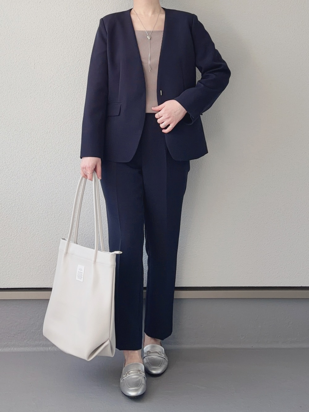 ブルー系のノーカラージャケット、ブルー系のその他パンツ、ホワイト系のトートバッグを着用したレディースの冬コーディネートの2枚目の写真