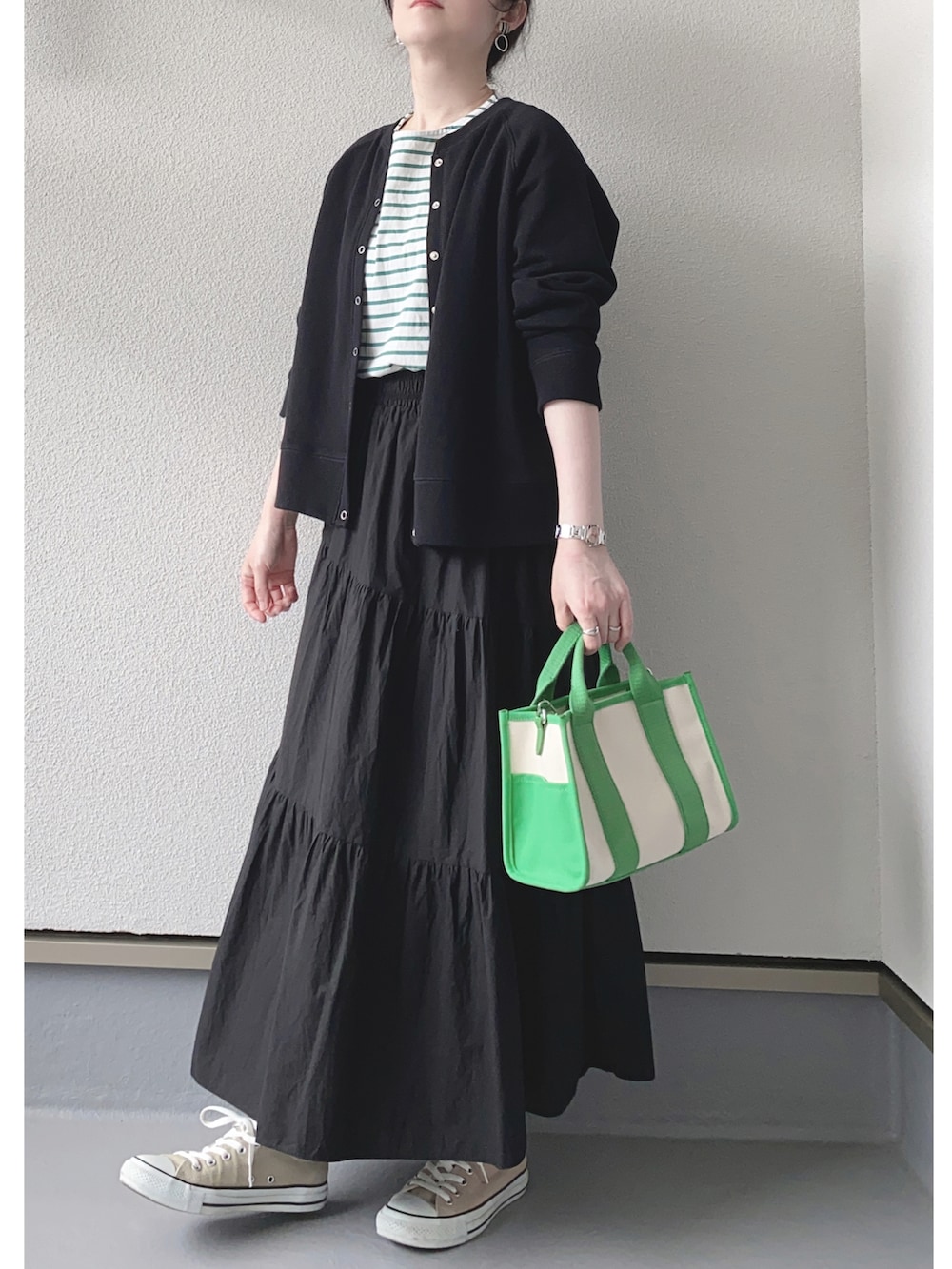 ブラック系のカーディガン/ボレロ、ホワイト系のTシャツ/カットソー、ブラック系のスカートを着用したレディースの春コーディネートの2枚目の写真