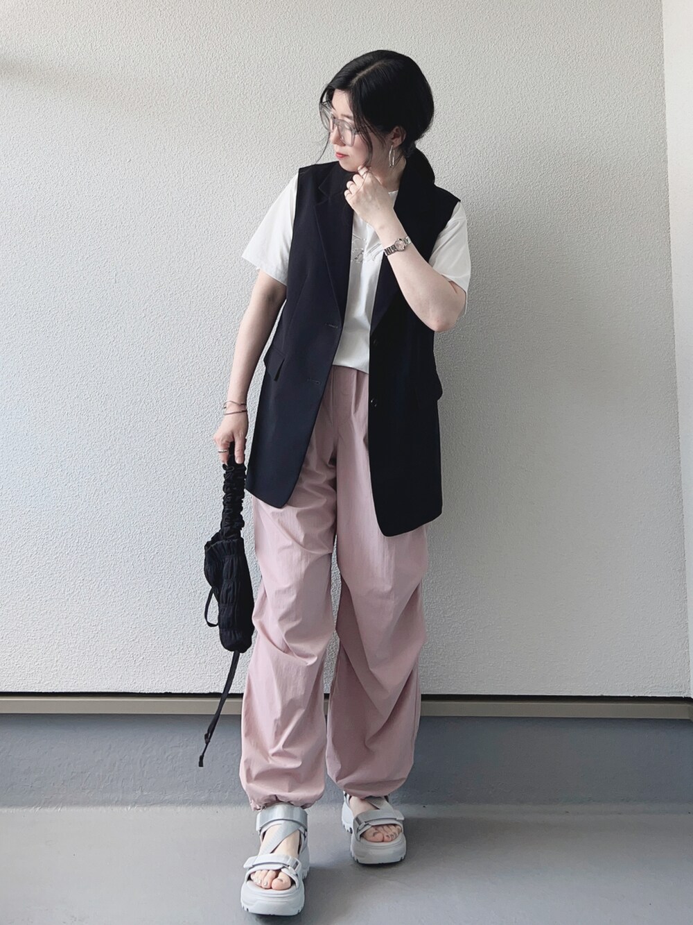 ホワイト系のTシャツ/カットソー、ブラック系のベスト、ピンク系のパンツを着用したレディースの春コーディネートの2枚目の写真