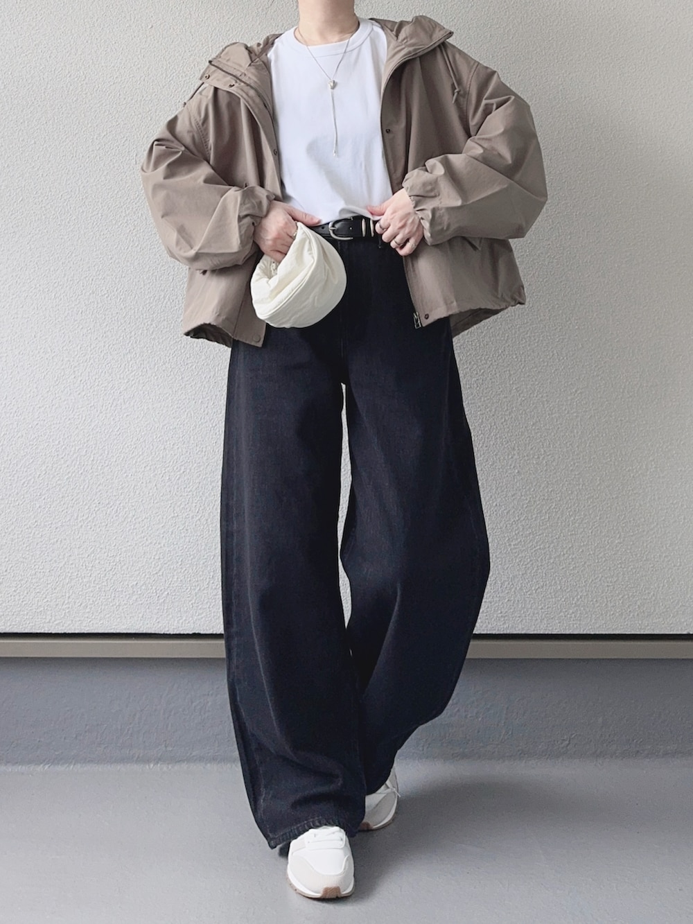 ホワイト系のTシャツ/カットソー、グリーン系のマウンテンパーカー、グレー系のデニムパンツを着用したレディースの秋コーディネートの2枚目の写真