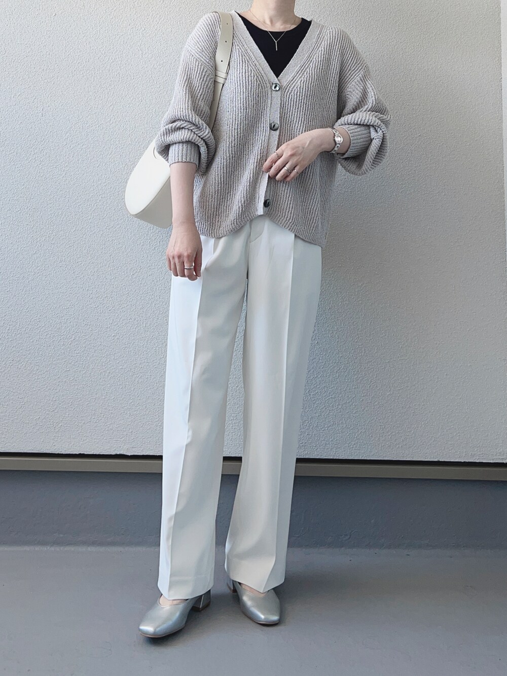 グレー系のカーディガン/ボレロ、ブラック系のタンクトップ、ホワイト系のスラックスを着用したレディースの春コーディネートの3枚目の写真