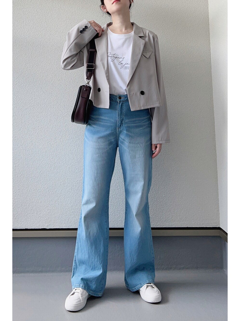 ホワイト系のTシャツ/カットソー、グレー系のテーラードジャケット、ブルー系のデニムパンツを着用したレディースの秋コーディネートの2枚目の写真