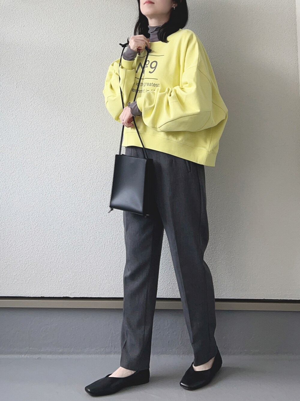 イエロー系のスウェット、グレー系のパンツ、ブラック系のシューズを着用したレディースの冬コーディネートの2枚目の写真