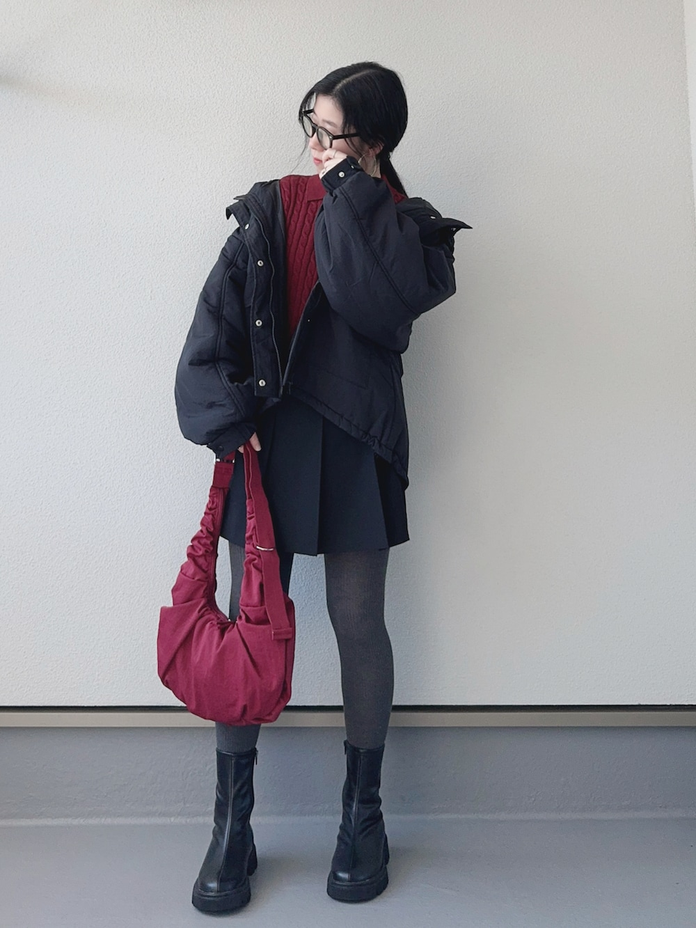 レッド系のニット/セーター、ブラック系のブルゾン、ブラック系のブーツを着用したレディースの秋コーディネートの4枚目の写真