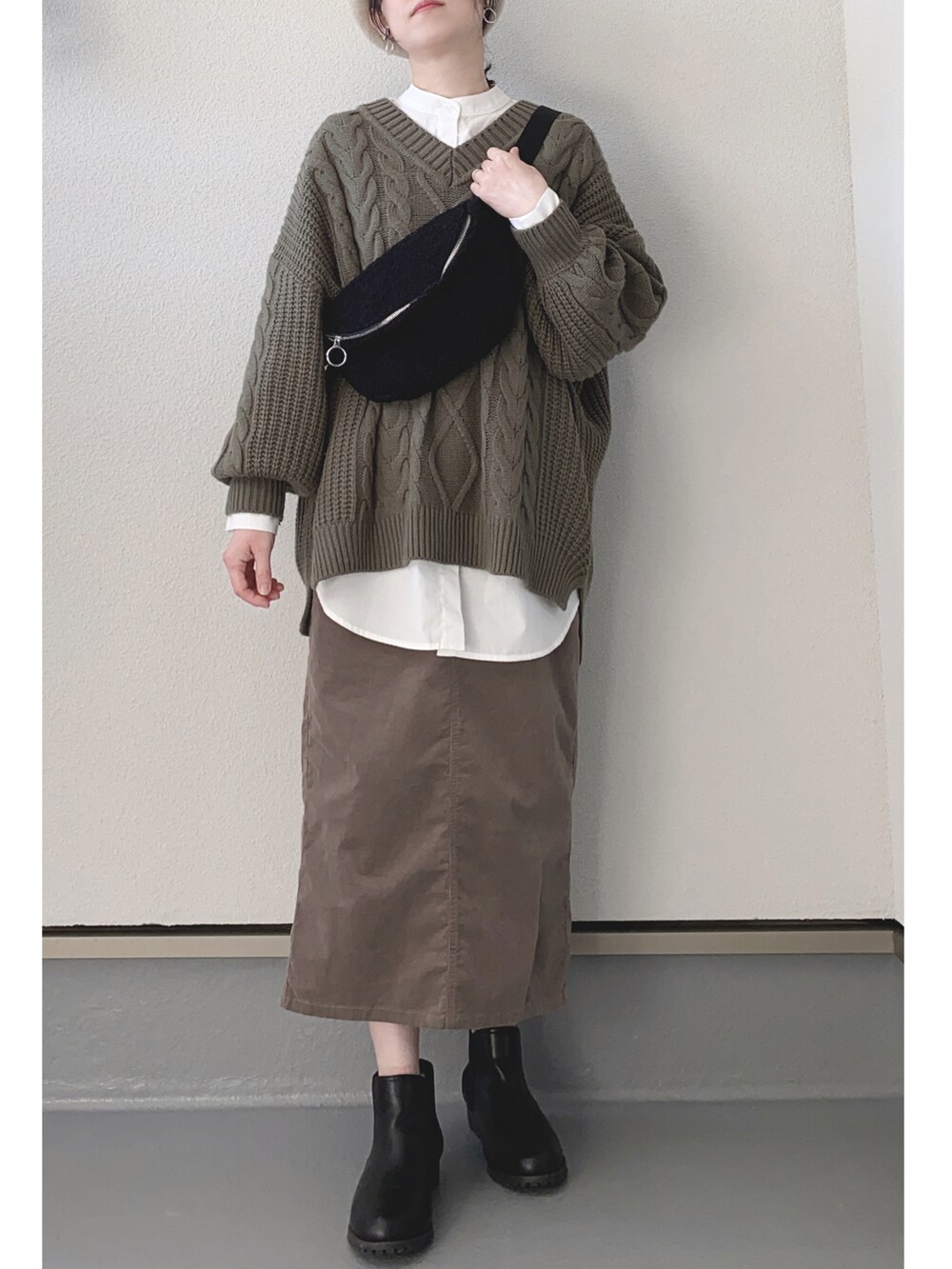 グリーン系のニット/セーター、ブラック系のシャツ/ブラウス、ブラウン系のスカートを着用したレディースの冬コーディネートの2枚目の写真