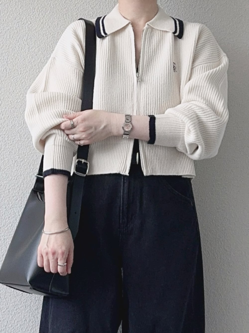ホワイト系のニット/セーター、グレー系のデニムパンツ、ブラック系のショルダーバッグを着用したレディースの秋コーディネートの2枚目の写真