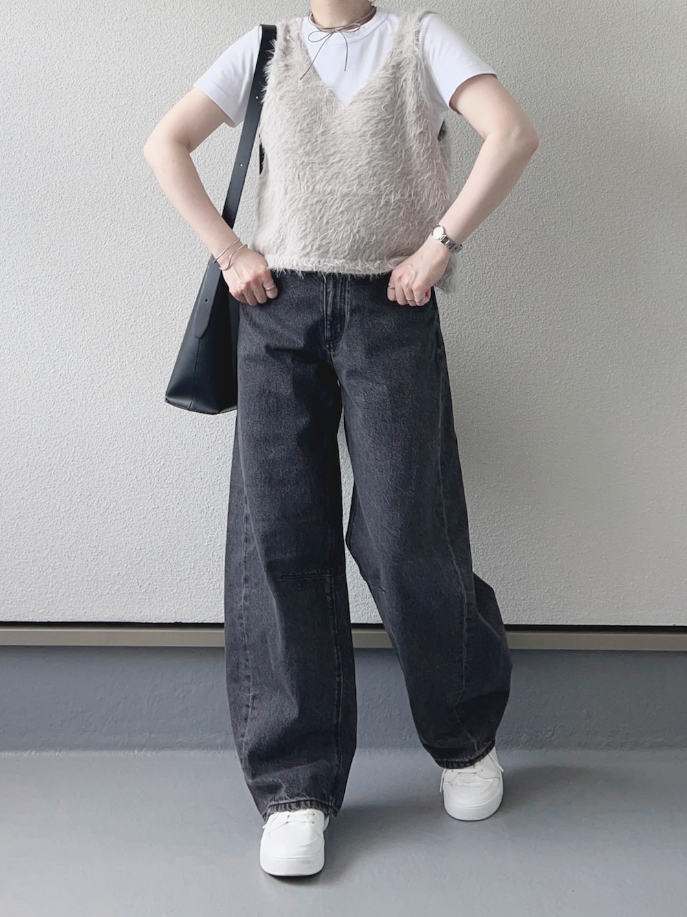グレー系のベスト、グレー系のデニムパンツ、ホワイト系のTシャツ/カットソーを着用したレディースの秋コーディネートの3枚目の写真