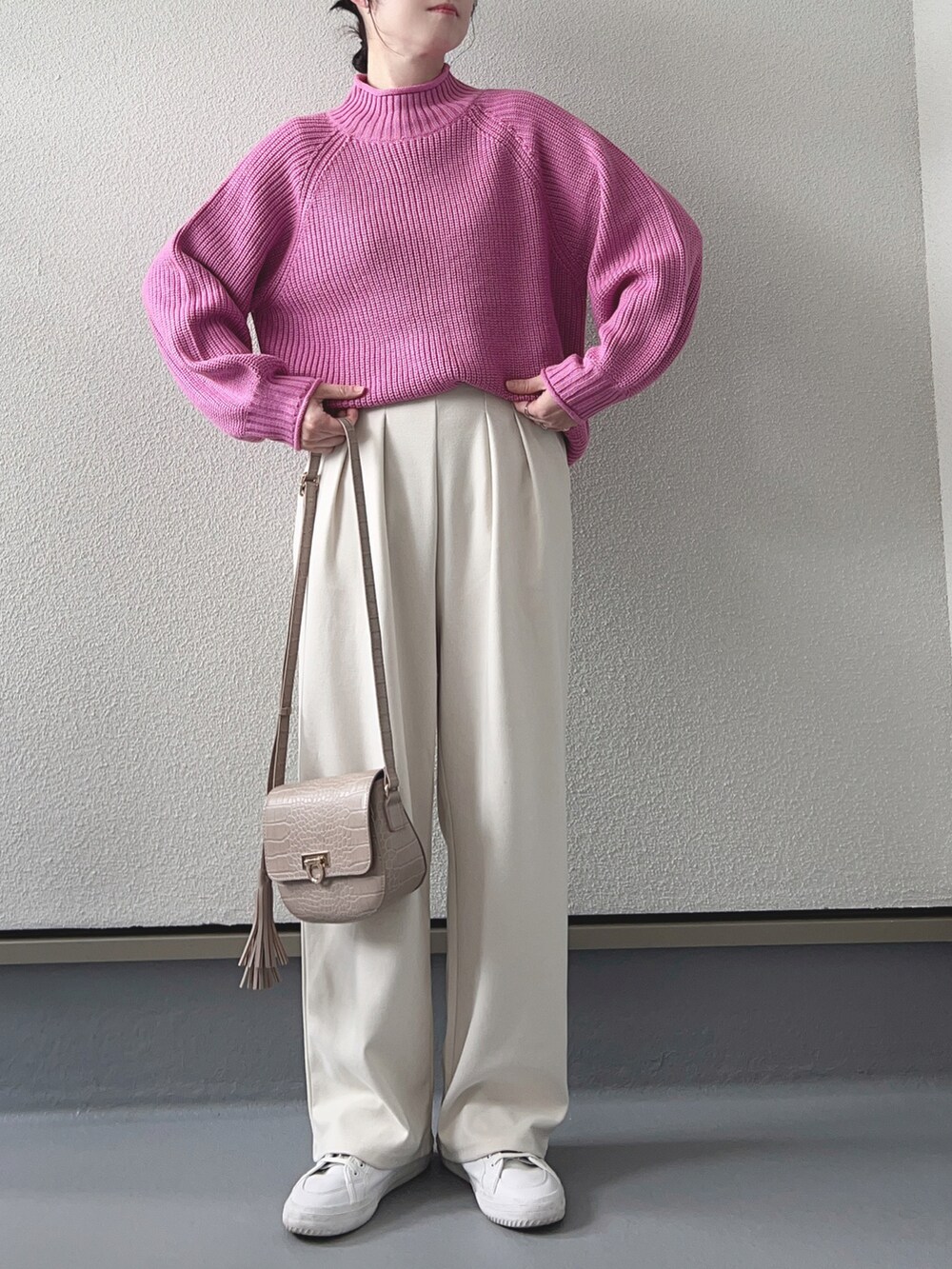 ピンク系のニット/セーター、ホワイト系のノーカラージャケット、ブラウン系のショルダーバッグを着用したレディースの冬コーディネートの2枚目の写真